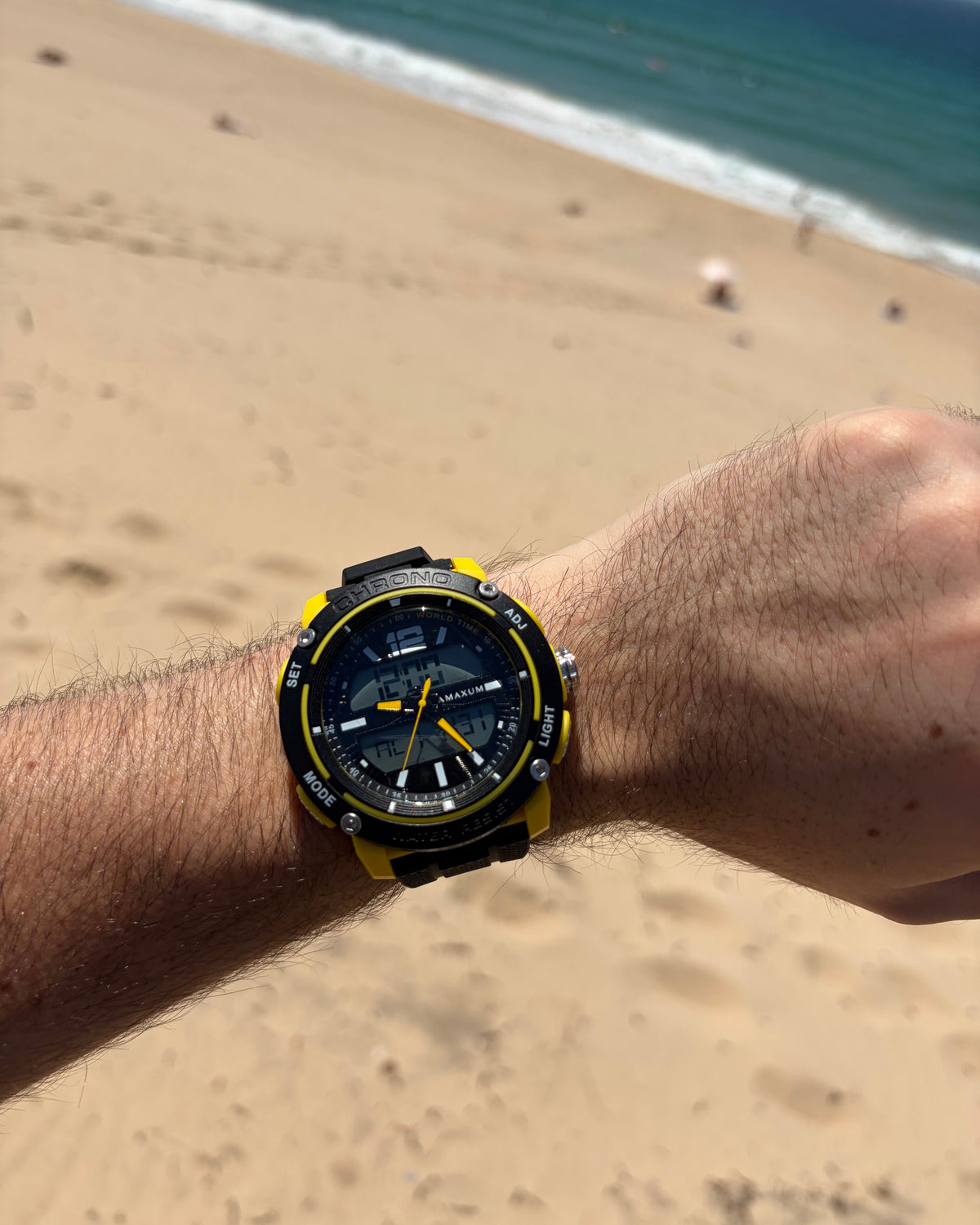 Maxum Conquest Analogue Digital Watch Black & Yellow with a silicone band and a digital display. On wrist at beach